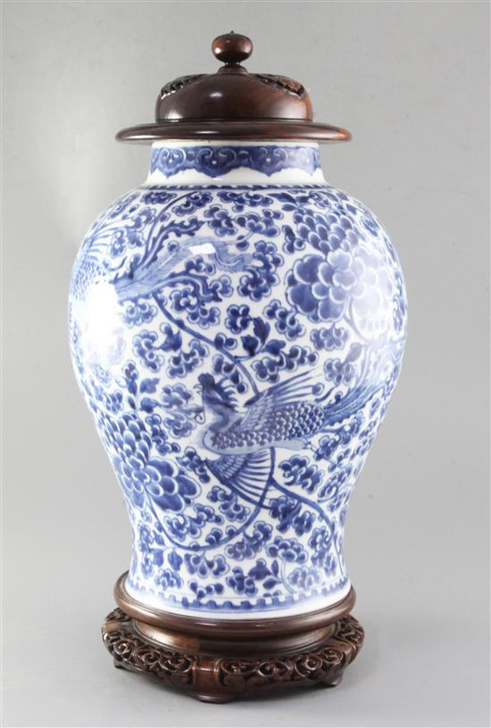 A Chinese blue and white phoenix and peony jar, Kangxi period, height 36cm, rosewood cover and stand